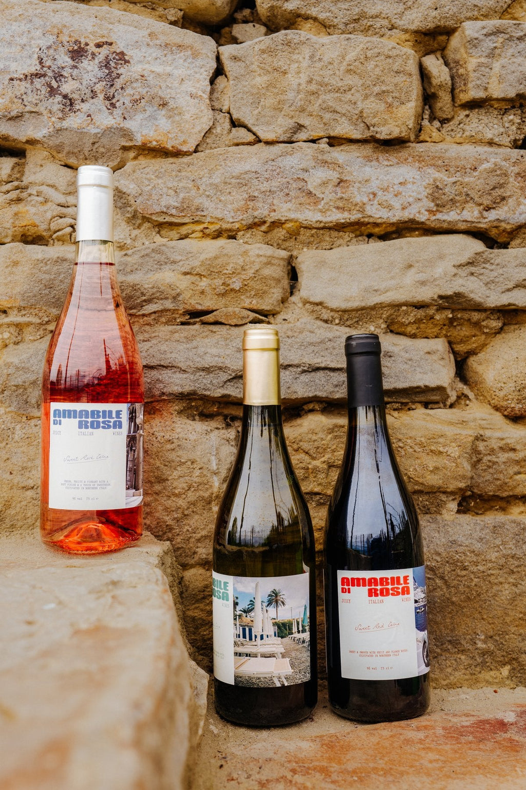 Amabile di Rosa bottles styled against a stone wall