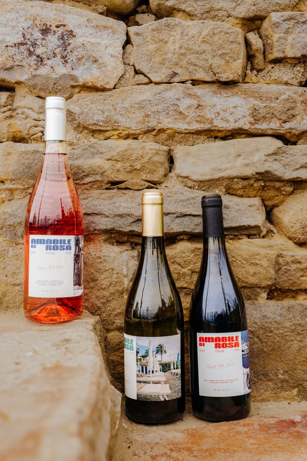 Amabile di Rosa bottles styled against a stone wall